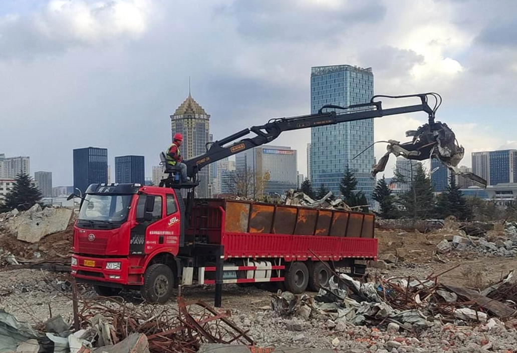 alt:Truck crane lifting heavy materials on a construction site with precision hydraulic system and robust chassis.